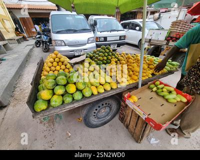 Une gamme de fruits tropicaux frais est disponible à la vente sur un marché local animé aujourd'hui Zanzibar Africa Banque D'Images