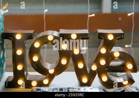 Le mot amour écrit avec des ampoules sous forme de lettres. Banque D'Images
