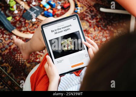 Paris, France - 11 juin 2023 : une personne tenant une tablette et lisant sur Apple Vision Pro, avec un article sur les expériences immersives affiché sur le Banque D'Images