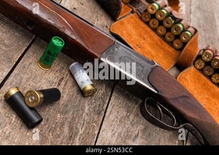 Fusil de chasse vintage avec des munitions sur une table en bois rustique dans un environnement de chasse Banque D'Images