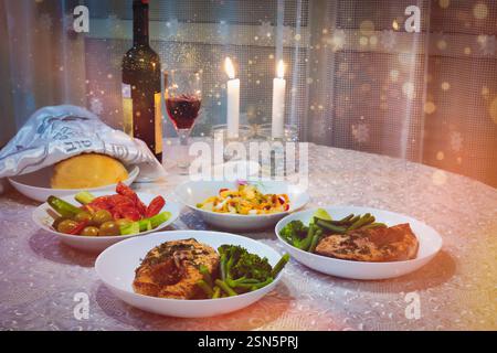 Challah pain et repas avec vin shabbat sur la table. Rituel traditionnel juif de Shabbat. Shabbat Shalom. Chandelles Shabbat allumées. Banque D'Images