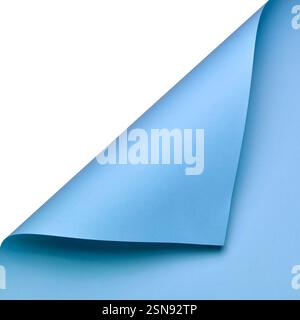 Une composition épurée et minimaliste avec une feuille de papier bleu lisse enroulée dans le coin. La couleur vibrante et le pli élégant créent une dynamique Banque D'Images