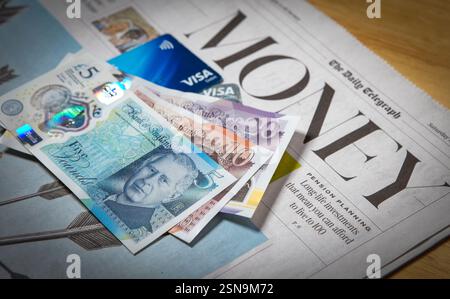 Une sélection de billets de banque britanniques et de cartes Visa dans la section argent et finances d'un journal britannique, février 2025 Banque D'Images