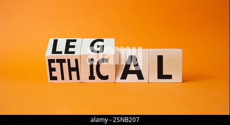 Symbole éthique et juridique. Cubes en bois tournés avec des mots éthiques et légaux. Beau fond orange. Business et concept éthique et juridique. Copier Banque D'Images