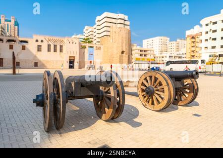Vue depuis les canons en face du fort Sharjah Al Hisn dans le centre de la ville de Sharjah, Émirats arabes Unis. Banque D'Images