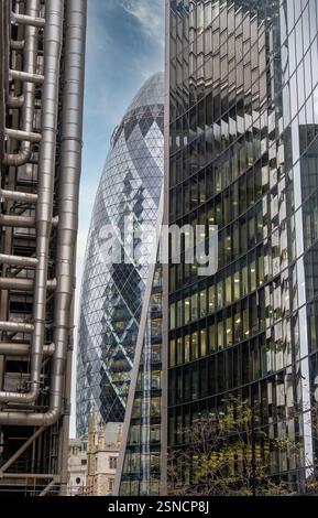 Chefs-d'œuvre architecturaux modernes dans le quartier financier de Londres - l'emblématique Gherkin Building encadré par Lloyd's of London et des gratte-ciel, mettant en vedette Urb Banque D'Images