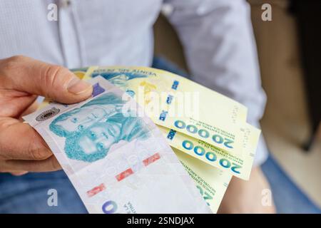 Argentine nouveaux billets de banque. homme d'affaires tenant des pesos argentins à la main. 10 et 20 000, gros cash. concept d'entreprise financière. croissance économique Banque D'Images