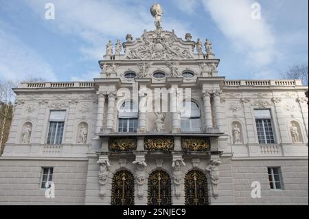 Un grand palais blanc à Munich, en Allemagne, avec un balcon orné d'une statue. Les détails architecturaux complexes et la nature environnante créent un pictu Banque D'Images