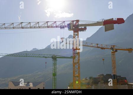 Construction grue et Maison et Alpes suisses avec ciel bleu et lumière du soleil à Andermatt, Uri, Suisse, Europe Banque D'Images