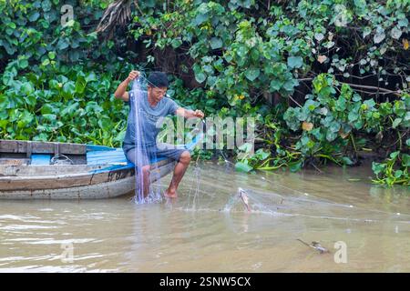 Un pêcheur attrape un poisson de son bateau, fleuve Mékong, Vietnam, lundi 11 novembre, 2024. photo : David Rowland / One-Image.com Banque D'Images