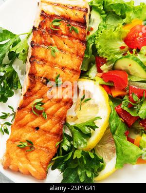 Steak de saumon avec légumes et frites. Fraîchement grillé. Dîner sain. Régime méditerranéen. Vue de dessus, pose à plat, espace de copie Banque D'Images