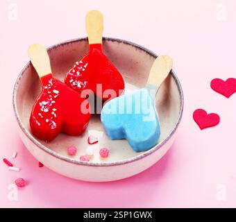 Différents types de crème glacée popsicle sur fond rose. Banque D'Images