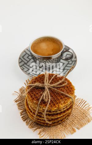 Des gaufres au caramel fraîchement préparées s'empilent à côté d'une tasse de café à la vapeur, créant une délicieuse friandise parfaite pour célébrer la journée nationale du caramel dans un cadre confortable Banque D'Images