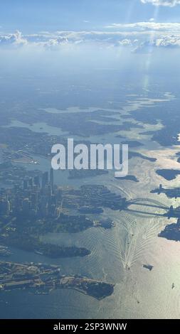 Panorama de Sydney : l'emblématique Opéra et Harbour Bridge dominent le paysage urbain étincelant, éclipsé par un port animé en contrebas. Cette vue aérienne capture Banque D'Images