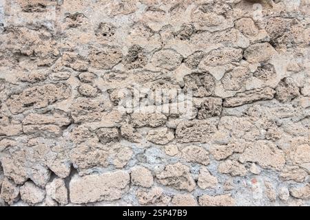 Une capture détaillée d'un mur de pierre vintage et rustique, mettant en valeur sa texture inégale, son motif naturel et son ambiance historique, idéal pour les arrière-plans Banque D'Images