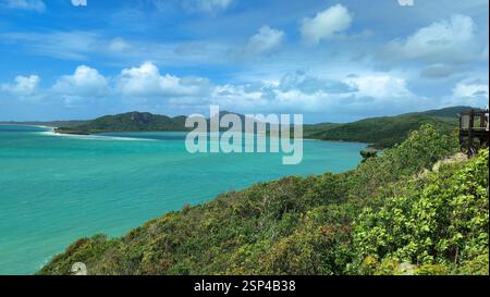 Une vue panoramique sur l'océan bleu vif avec des vagues blanches s'écrasant contre des falaises verdoyantes est capturée sur la photo. Il dépeint le beau paysage o Banque D'Images