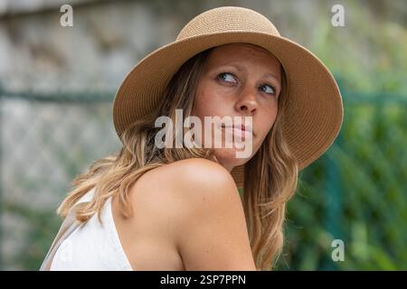 Femme réfléchie portant un chapeau de paille regardant dehors Banque D'Images