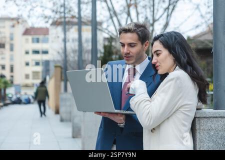 Hommes d'affaires travaillant avec un ordinateur portable dans la rue de la ville Banque D'Images