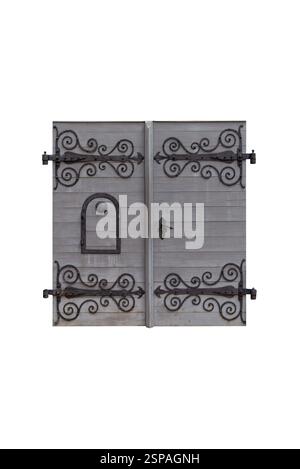 Élégantes portes en bois vieilli avec charnières en fer pleine longueur et ornements floraux, bois de teinte grise, trou de regard et serrure noire ornée, parfaites pour le bu historique Banque D'Images