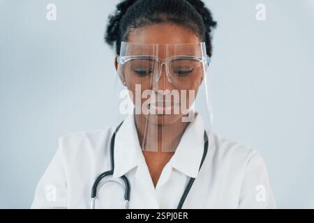 Dans l'équipement de protection. La jeune femme afro-américaine est sur fond blanc. Banque D'Images