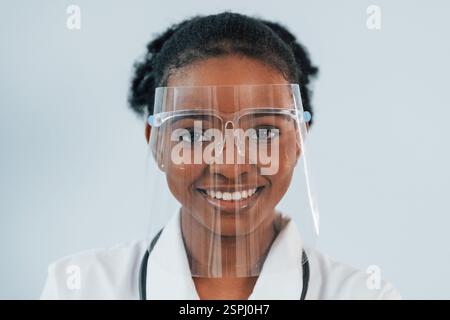 Dans l'équipement de protection. La jeune femme afro-américaine est sur fond blanc. Banque D'Images