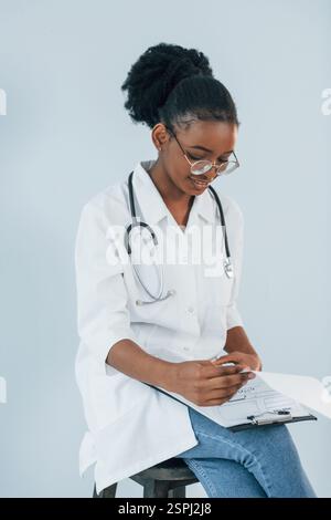 La jeune femme afro-américaine est sur fond blanc. Banque D'Images