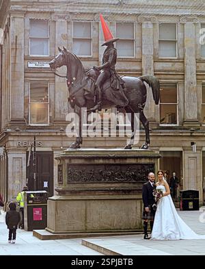 Glasgow, Écosse, Royaume-Uni. 14 février 2025. Météo Royaume-Uni : ensoleillé jour de printemps et froid pour la Saint-Valentin dans la ville comme les premiers signes appear.in le centre de la ville que les habitants et les touristes prennent dans les rues. L'amour est dans l'air alors qu'un couple pose devant l'homme à tête conique emblématique devant le musée de moderne équipé Crédit Gerard Ferry/Alamy Live News Banque D'Images