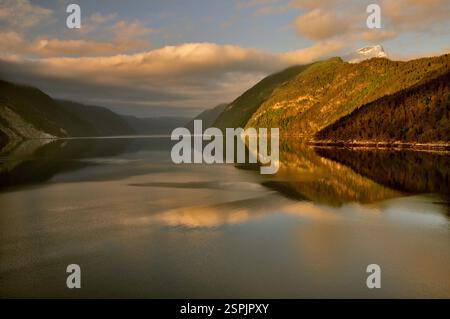 Réflexions dans le Storfjord dans l'ouest de la Norvège au lever du soleil le jour du milieu de l'été 2009. Banque D'Images