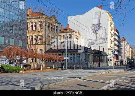 LYON, FRANCE, 14 février 2025 : Un portrait du célèbre chef Paul Bocuse est peint sur un mur devant les Halles de Lyon, qui portent son nom. Banque D'Images