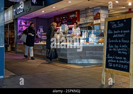 LYON, FRANCE, 14 février 2025 : boutiques de célèbres spécialités traditionnelles aux Halles de Lyon, qui portent le nom du célèbre chef Paul Bocuse Banque D'Images