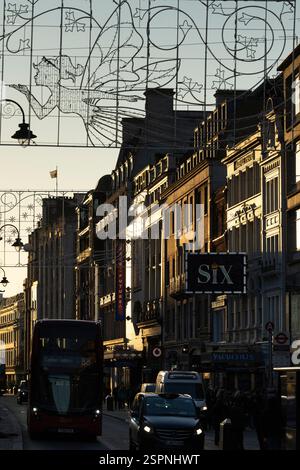 Scène de soirée sur le Strand, Londres, près du Théâtre Vaudeville. Bus et voitures sont dans la rue, et les chapiteaux de théâtre sont éclairés. Banque D'Images