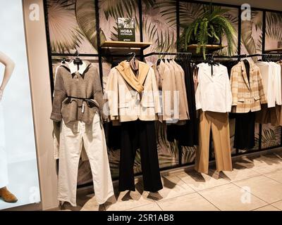 Lviv, Ukraine - 13 février 2025 : une variété de vêtements élégants accrochés dans un magasin de détail bien conçu. Banque D'Images
