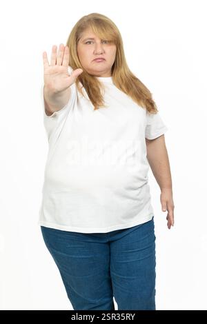 Portrait d'une femme blonde plus grande taille levant la main dans un geste d'arrêt. Banque D'Images