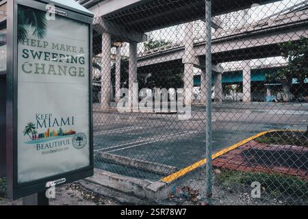 Panneau « Keep Miami Beautiful » près d'un parking abandonné où il y a des tentes de sans-abri en arrière-plan Banque D'Images