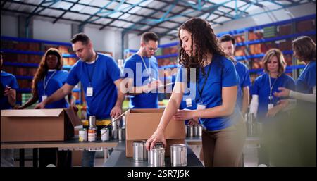 Des bénévoles communautaires trient des aliments donnés pour le programme de sensibilisation des fondations caritatives. Banque D'Images