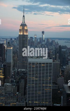 New York City enveloppée dans la lueur chaude du crépuscule. L'Empire State Building, une balise rayonnante, traverse le ciel assombri. Ce symbo d'image intemporel Banque D'Images