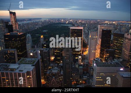 Manhattan, New York City, se déploie comme une tapisserie scintillante la nuit. Un spectacle éblouissant de lumières chaudes et fraîches baigne le groupe dense de skyscrap Banque D'Images