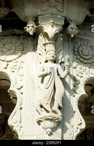 Une femme avec un chapeau de plumes sur sa tête sculpté dans la pierre sur le mur de chhatri au temple Maheshwar, Madhya Pradesh, Inde, Asie Banque D'Images