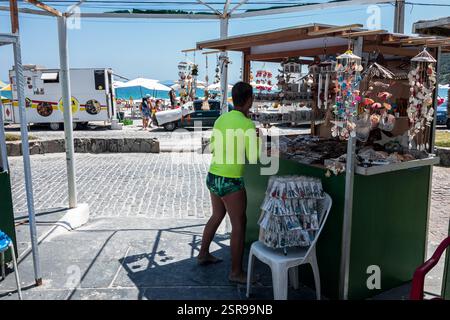 Étal de rue dynamique vendant des souvenirs près de la plage de Prainha sur l'avenue Alfredo Dante Fassini sous un ciel bleu clair et ensoleillé matin d'été. Banque D'Images