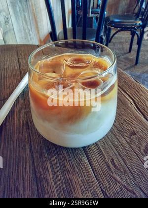 Café glacé / latte glacé avec des glaçons dans un verre sur une table dans un café Banque D'Images