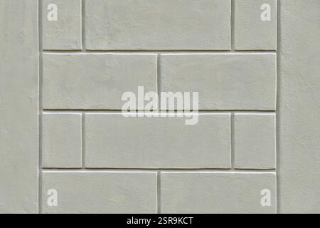 Élégante texture architecturale grise avec un effet rustique, typique des façades italiennes historiques. Cette surface en plâtre imite la pierre sculptée, créant un Banque D'Images