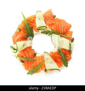 La moitié de délicieux bagel au saumon, fromage à la crème et concombre isolé sur blanc, vue de dessus Banque D'Images