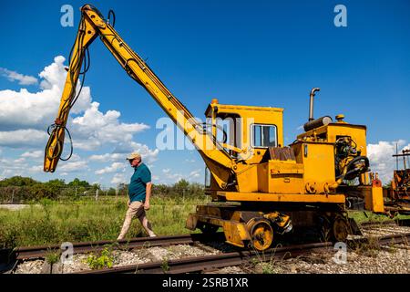 Un homme passe devant une grue de cravate de chemin de fer vintage exposée au Fort Wayne Railroad Historical Society Museum à New Haven, Indiana, États-Unis. Banque D'Images