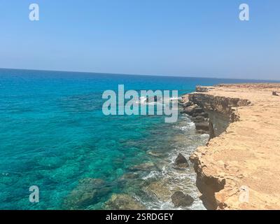 Vue imprenable depuis une falaise à Chypre, surplombant la mer turquoise cristalline et la côte accidentée, mettant en valeur la beauté de la Méditerranée Banque D'Images