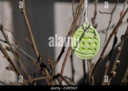 Faites-le vous-même sécher l'air de l'artisanat d'argile pour les vacances de Pâques. Décoration durable idée cadeau écologique artisanale pour enfants artisanaux. Instruction étape par étape de la peinture, pressant des chiffres sur une brindille en bois Banque D'Images