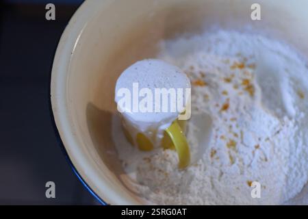 une tasse avec de la mousse de levure dans un bol avec de la farine, pétrissant la pâte Banque D'Images