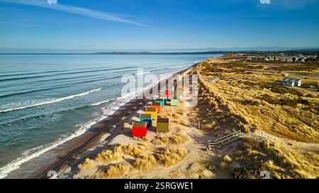 Findhorn Moray Coast Scotland rangée de cabanes de plage colorées sur les dunes de sable couvertes d'herbiers marins Banque D'Images