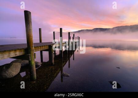 Beau lever de soleil brumeux avec jetée en bois à Derwentwater dans le Lake District, Royaume-Uni. Banque D'Images