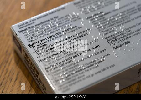 Braille sur une boîte de médicament contre le mal de gorge, Royaume-Uni. Le braille est un modèle ap de points surélevés qui est un système d'écriture utilisé par les personnes aveugles et malvoyantes Banque D'Images