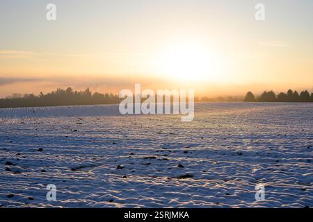 Collines ondulantes pittoresques dans la campagne britannique sur un lever de soleil d'hiver avec le soleil bas à l'horizon. Banque D'Images